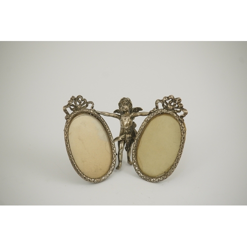 50 - A late 19th century Hanau silver double oval photograph frame, supported by central figure of Cupid,... 