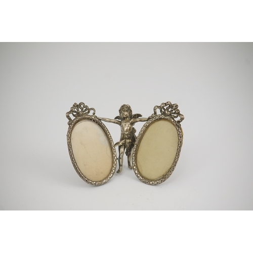 50 - A late 19th century Hanau silver double oval photograph frame, supported by central figure of Cupid,... 