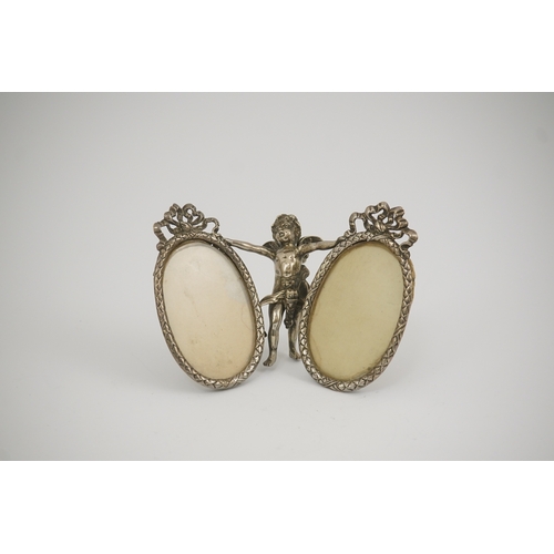 50 - A late 19th century Hanau silver double oval photograph frame, supported by central figure of Cupid,... 