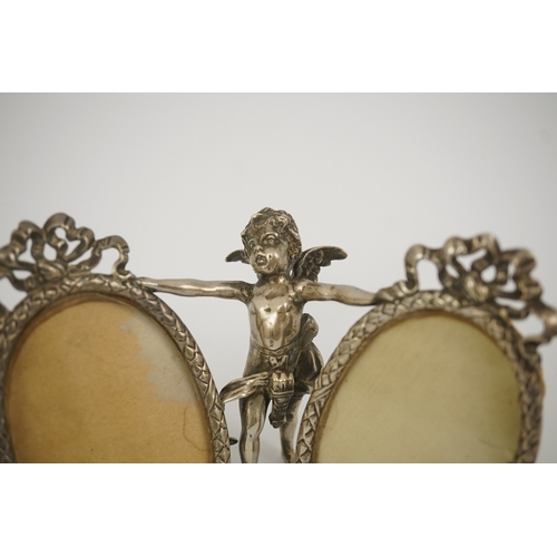 50 - A late 19th century Hanau silver double oval photograph frame, supported by central figure of Cupid,... 