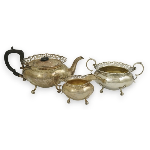 63 - A George V three piece silver circular tea set by James Deakin & Sons, with pierced borders, Sheffie... 