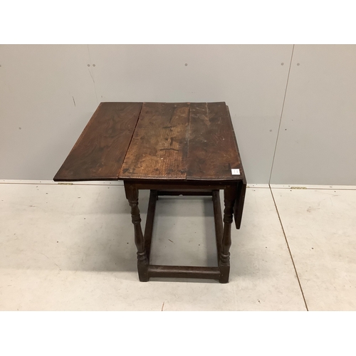 1014 - A 17th century rectangular oak drop leaf table on turned legs stretcher rail, label with '165' on th... 