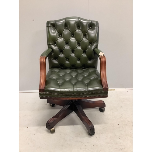 1084 - A reproduction mahogany and buttoned green leather swivel desk chair, width 56cm, depth 50cm, height... 