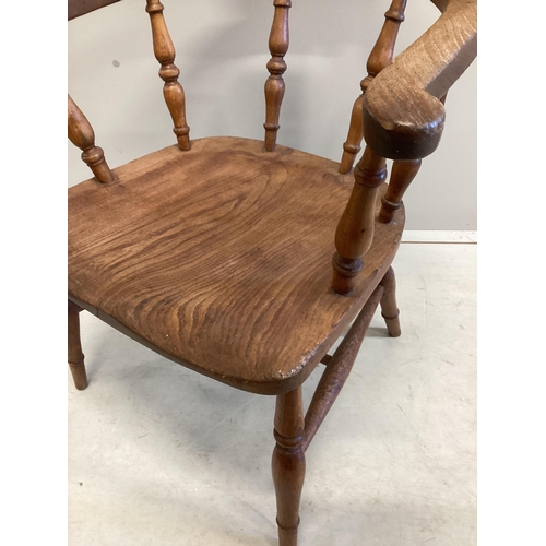 1163 - A Victorian elm and beech smoker's bow elbow chair on slender turned baluster legs with H stretcher,... 