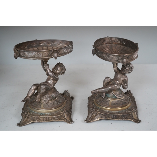 1304 - A pair of early 20th century Elkington & Co. silver plated putti stands, 17cm. Condition - fair to... 