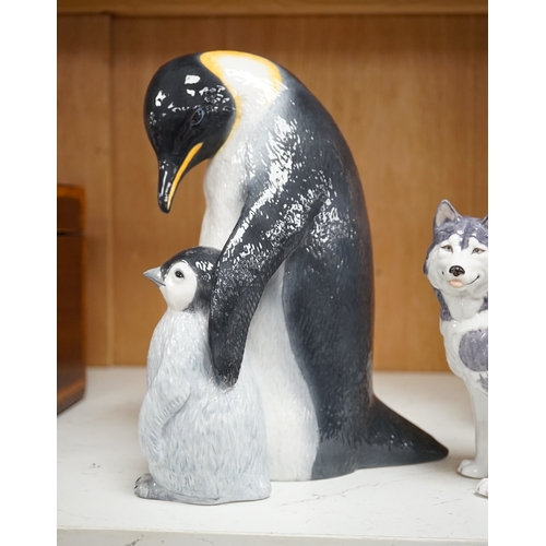 1365 - A Royal Copenhagen penguin group and a similar husky figure, 088 and 038, tallest 22cm. Condition - ... 