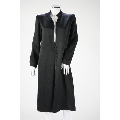 1512 - A 1930's black satin evening coat, with small collar and covered buttons to the front. Decorated wit... 