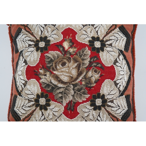 1516 - A 19th century Berlin bead worked cushion, the beadwork embroidered as a central rose, surrounded by... 