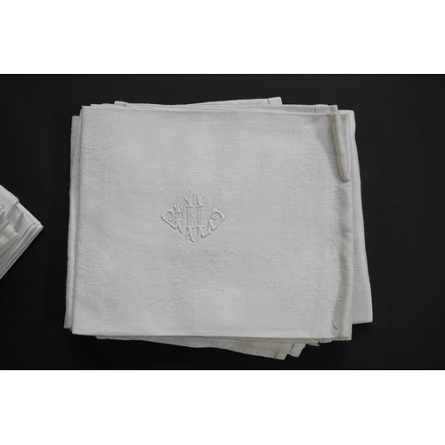 1523 - A set of nine red monogrammed 19th century large damask dinner napkins and a similar set of coarser ... 