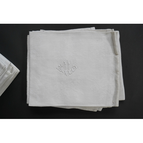 1523 - A set of nine red monogrammed 19th century large damask dinner napkins and a similar set of coarser ... 