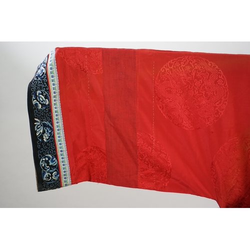 1528 - A late 19th century Chinese Manchu ladies red silk damask robe, with black and blue silk embroidered... 