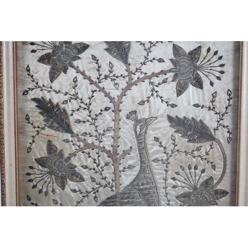 1535 - An Indian late 19th century silver metallic thread embroidery of a peacock in a flowering tree, embr... 