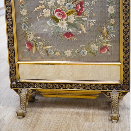 1538 - A late 19th century gilt framed silk and wool work embroidered fire screen, embroidered with a centr... 