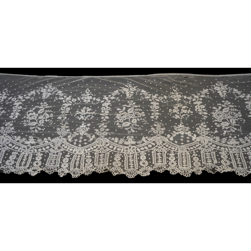 1546 - A deep elaborately designed flounce of mid 19th century Brussels bobbin appliquéd lace on net, with ... 