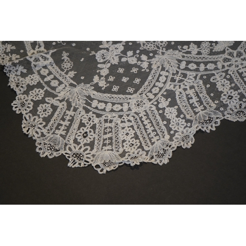 1546 - A deep elaborately designed flounce of mid 19th century Brussels bobbin appliquéd lace on net, with ... 