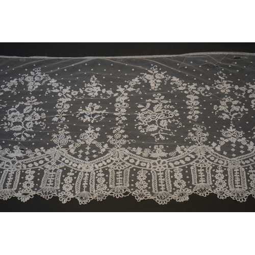 1546 - A deep elaborately designed flounce of mid 19th century Brussels bobbin appliquéd lace on net, with ... 