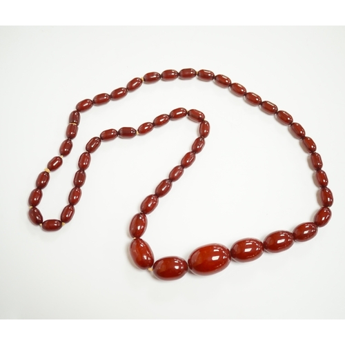 1905 - A single strand graduated simulated cherry amber oval bead necklace, 70cm, gross weight 51 grams. Co... 