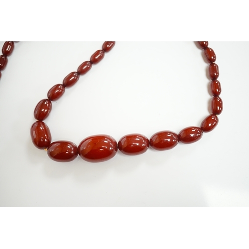 1905 - A single strand graduated simulated cherry amber oval bead necklace, 70cm, gross weight 51 grams. Co... 