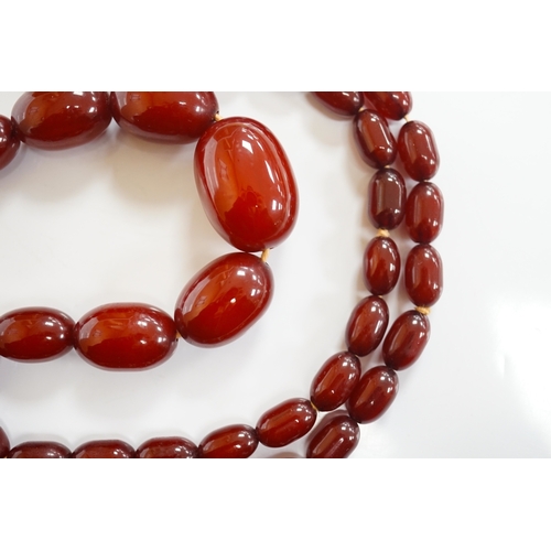 1905 - A single strand graduated simulated cherry amber oval bead necklace, 70cm, gross weight 51 grams. Co... 