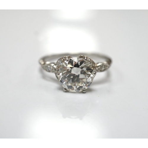 1908 - A platinum and single stone diamond set ring, with six stone diamond chip set foliate shoulders, the... 