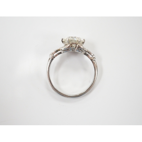 1908 - A platinum and single stone diamond set ring, with six stone diamond chip set foliate shoulders, the... 