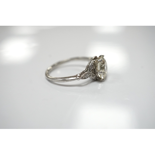 1908 - A platinum and single stone diamond set ring, with six stone diamond chip set foliate shoulders, the... 