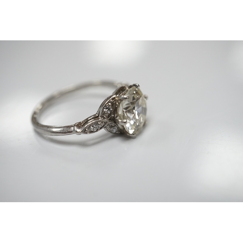 1908 - A platinum and single stone diamond set ring, with six stone diamond chip set foliate shoulders, the... 