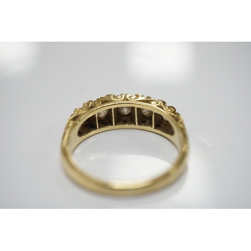 1910 - A modern Victorian style 18ct gold and graduated five stone diamond set half hoop ring, with rose se... 