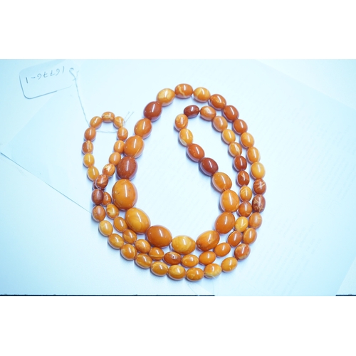 1926 - A single strand graduated oval amber bead necklace, 110cm, gross weight 103 grams. Condition - poor ... 