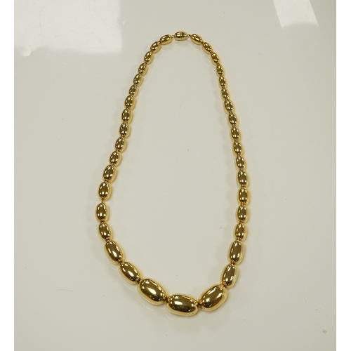 1950 - A modern gilt metal graduated oval bead costume necklace, 72cm. Condition - fair to good