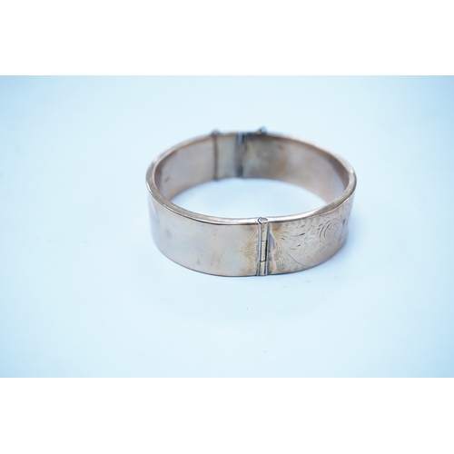 1959 - A 1960's engraved 9ct gold hinged bangle, 24.1 grams. Condition - poor