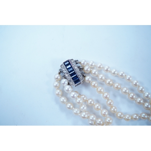 1963 - A triple strand cultured pearl choker necklace, with sapphire and diamond cluster set rectangular wh... 