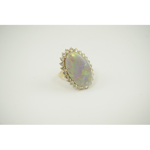 1966 - An 18ct  gold, white opal and diamond set oval cluster dress ring, the cabochon opal measuring appro... 