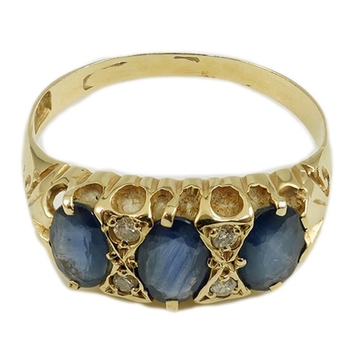 1968 - An Edwardian 15ct gold and three stone oval cut sapphire set half hoop ring, with diamond chip space... 