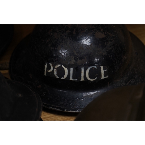 257 - Seven early to mid 20th century military tin helmets; including one stencilled with POLICE. Conditio... 