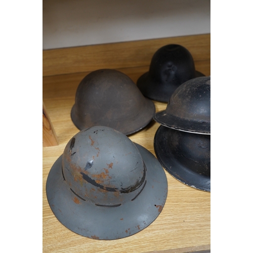 257 - Seven early to mid 20th century military tin helmets; including one stencilled with POLICE. Conditio... 