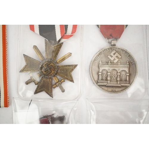 294 - Nine German WWII medals; three Blood Order medals, a Second class Iron Cross, a War Merit medal in i... 