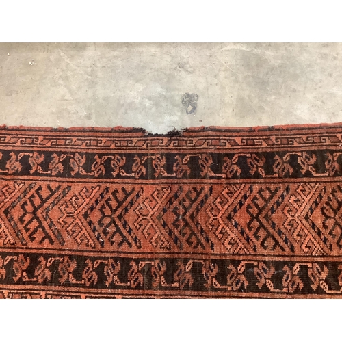 37 - An Afghan rust ground carpet, 400 x 260cm. Condition - poor, damage to border