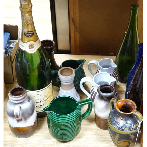 498 - A collection of studio pottery and four glass bottles to include an oversized advertising bottle of ... 