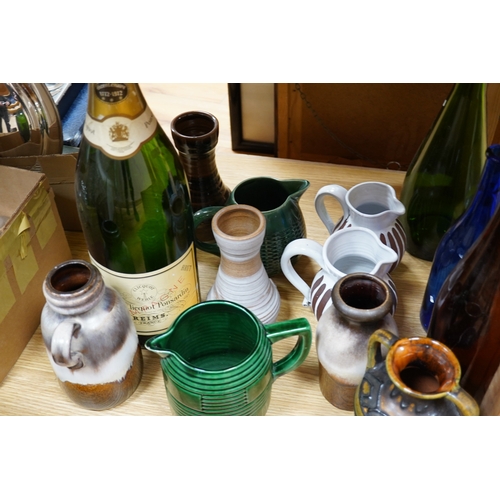 498 - A collection of studio pottery and four glass bottles to include an oversized advertising bottle of ... 