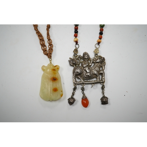 589 - A Chinese celadon and russet jade cicada pendant on cording and a silver and stone mounted chain and... 