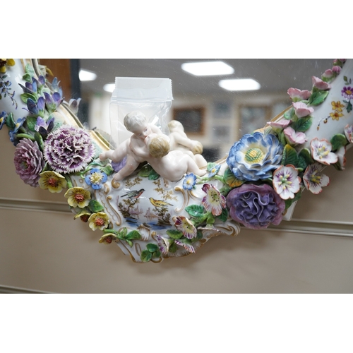 630 - A Meissen style porcelain floral encrusted and figural mirror, 64cm high. Condition - fair, minor lo... 