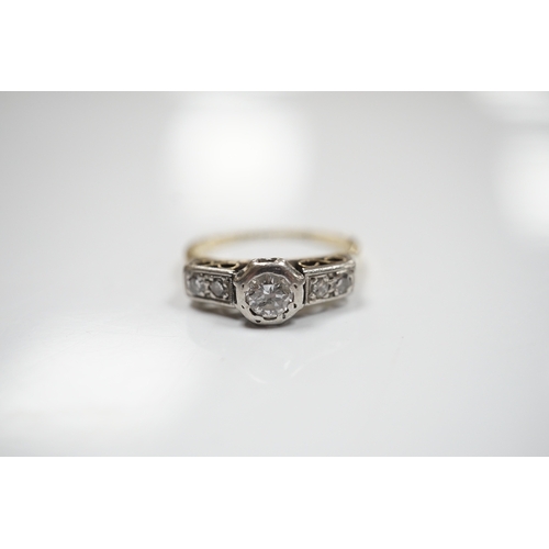 907 - An 18ct, plat. and collet set single stone diamond ring, with four stone diamond set shoulders, size... 