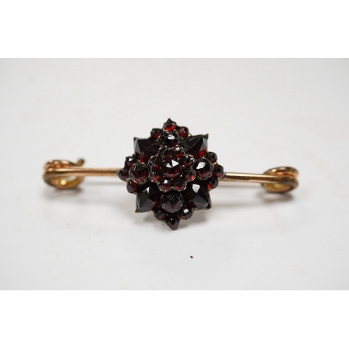 921 - A rolled gold and garnet cluster set bar brooch, 44mm (adapted). Condition - poor to fair