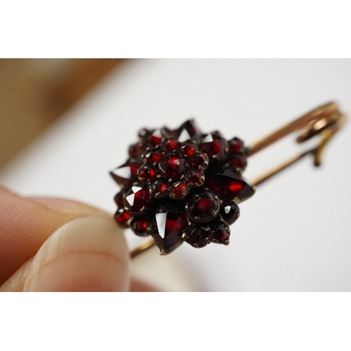 921 - A rolled gold and garnet cluster set bar brooch, 44mm (adapted). Condition - poor to fair