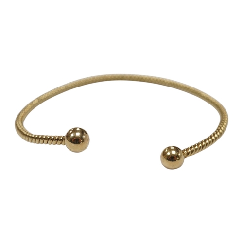 939 - A modern 9ct gold open work bangle, with spherical terminals, 8.4 grams. Condition - fair