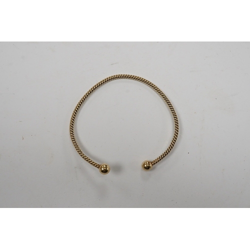 939 - A modern 9ct gold open work bangle, with spherical terminals, 8.4 grams. Condition - fair