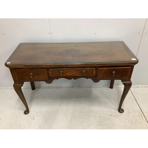 1028 - A George II style feather and cross banded walnut three drawer serving table, width 136cm, depth 53c... 