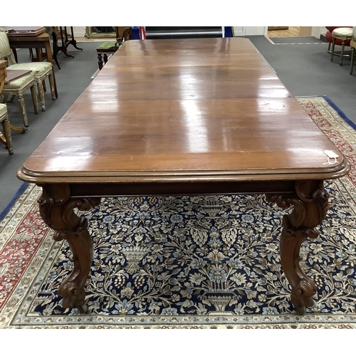 1099 - A Victorian oak extending dining table on carved cabriole legs, width 320cm extended, three spare le... 