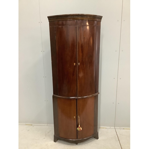 1107 - A George III mahogany bow front corner cupboard on later base, width 70cm, depth 46cm, height 179cm.... 